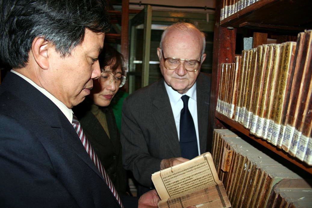 Father George McLean examining rare classical manuscripts in a national research library in Hanoi, Vietnam
